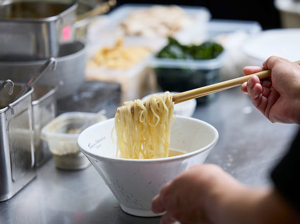 調理中のキッチンの様子。ラーメンの盛り付け